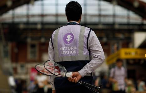 Rail worker holding two badminton rackets behind their back